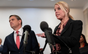 Woman speaking at press conference with microphones