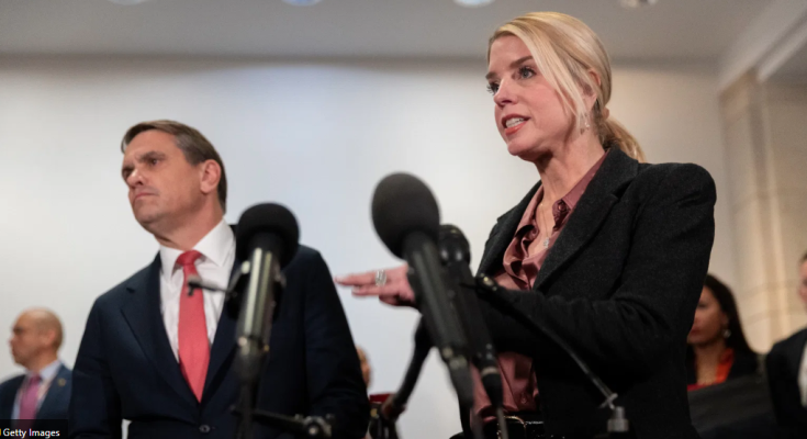 Woman speaking at press conference with microphones