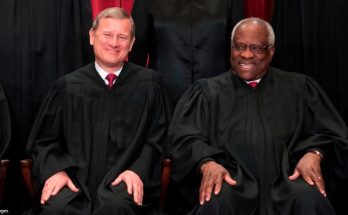Chief Justice Roberts and Justice Thomas in black robes seat