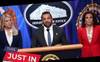 Man speaking at DOJ press conference with two women beside