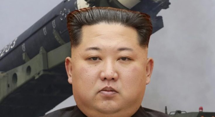 kim Jong Un stands before a large military missile launcher marked with numbers 205