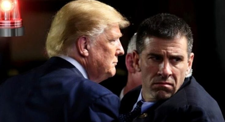 donald Trump and a man in suits facing each other with a red light in the background