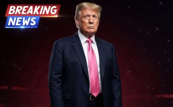 donald Trump in dark suit and pink tie against red background with Breaking News graphic