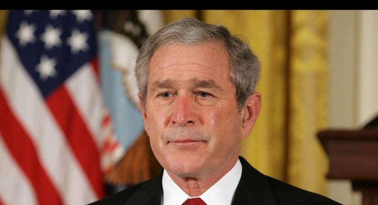 former President George W. Bush with tear on cheek during formal address, American flag