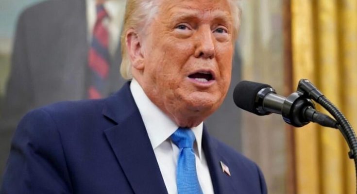 donald Trump speaking at podium with blue tie, partial BREAKING text visible, portrait