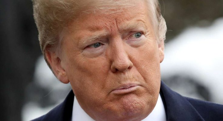 donald Trump in navy suit and red tie with serious expression outdoors
