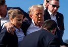 donald Trump surrounded by Secret Service agents with blood visible on his ear and face