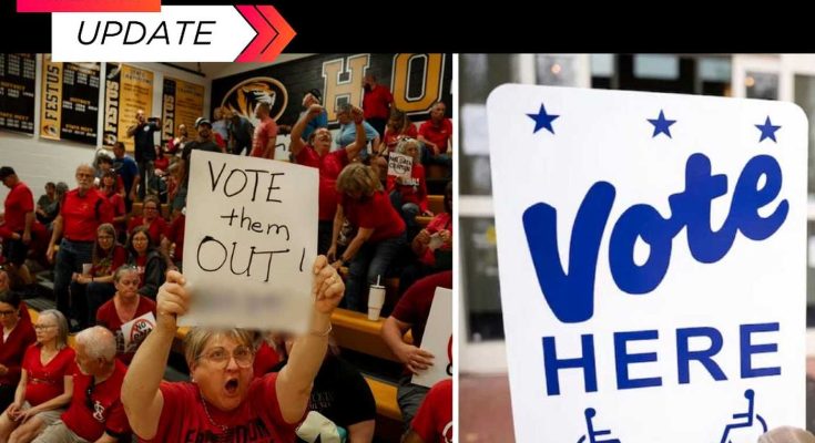 protester in red shirt holds handwritten VOTE them OUT sign beside official Vote Here