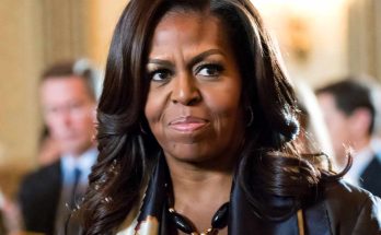 michelle Obama wearing statement necklace and patterned scarf at formal indoor event