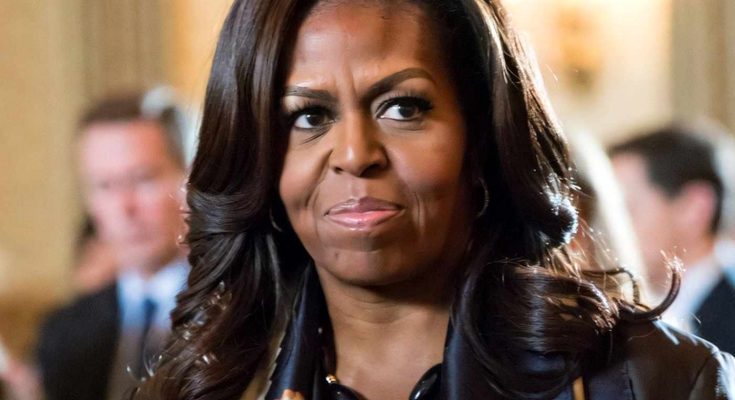 michelle Obama wearing statement necklace and patterned scarf at formal indoor event