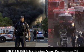 police officer stands before thick black smoke rising from building fire with emergency