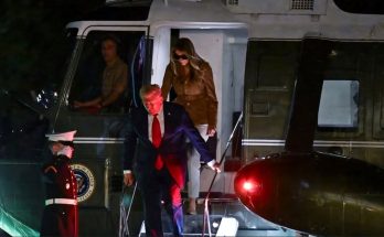 donald Trump descends Marine One stairs at night while Melania Trump follows wearing