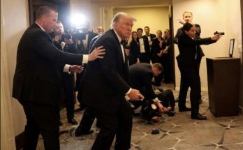 secret Service agents evacuate Donald Trump through hotel hallway with glass debris on