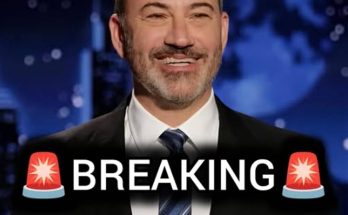 jimmy Kimmel in dark suit with striped tie, smiling against blue globe backdrop with
