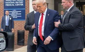 donald Trump in navy suit and red tie being escorted by Secret Service agents outside