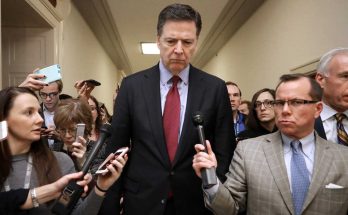 former FBI Director James Comey walks through Capitol hallway surrounded by reporters