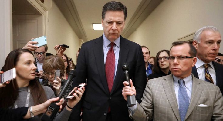 former FBI Director James Comey walks through Capitol hallway surrounded by reporters